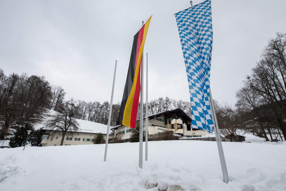 Eine deutsche und eine bayerische Flagge wehen vor dem Tagungsort Sankt Quirin, in dem die Haushaltsklausur der bayerischen Staatsregierung stattfindet.