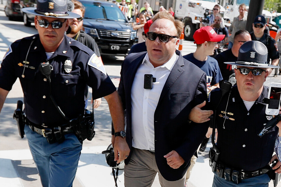 Jones wird bei einer Demo in Cleveland durch US-Polizisten abgeführt. Die Unterstützung Trumps sollte dem Verschwörungstheoretiker schließlich zum Verhängnis werden.