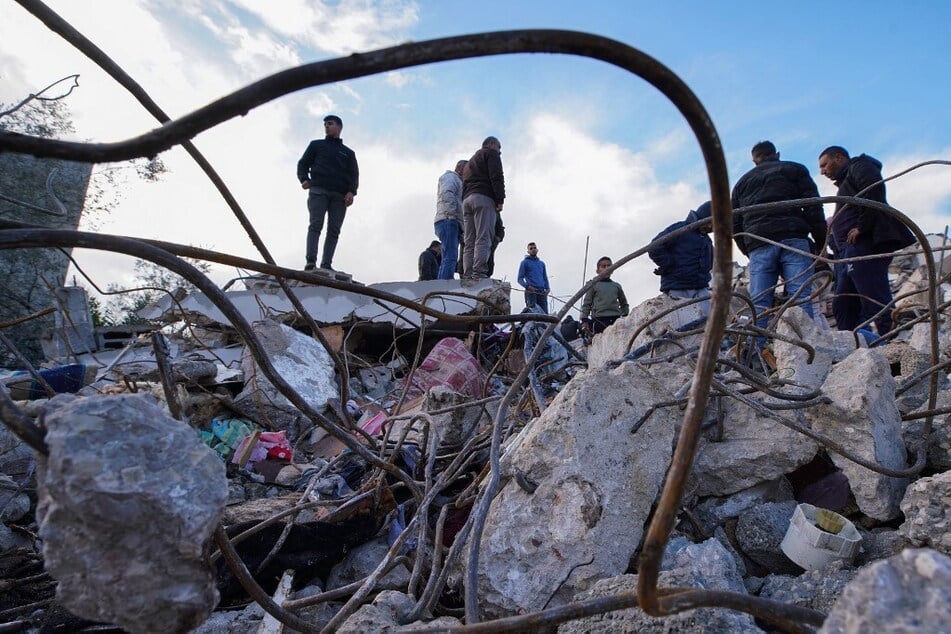 People inspect the rubble of a house where two Palestinians were killed during an Israeli raid in Burqin village near Jenin in the occupied West Bank on January 23, 2025.