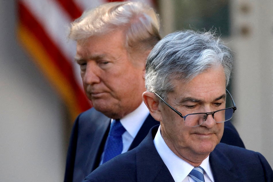 President Donald Trump (behind) has repeatedly insulted Federal Reserve Chair Jerome Powell over the decision not to lower interest rates.