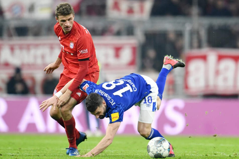 Thomas Müller (l.) von München schaut auf den strauchelnden Daniel Caligiuri von Schalke. Am 03.03.2020 trifft der FC Bayern im DFB-Pokal auf Schalke. (Archivbild)