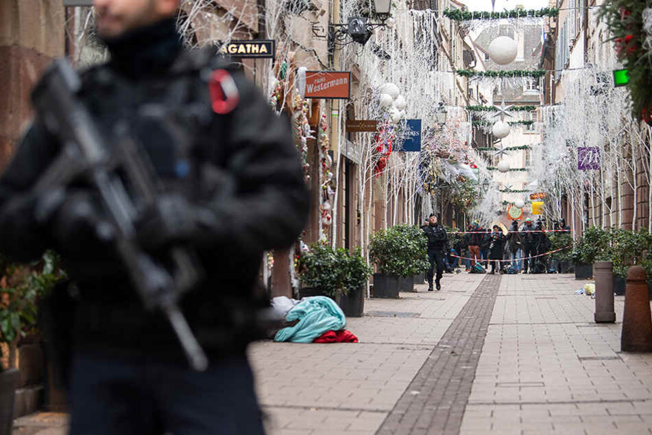 Ein Polizist steht nach dem Angriff in der Gegend des Straßburger Weihnachtsmarkts vor einem Tatort.