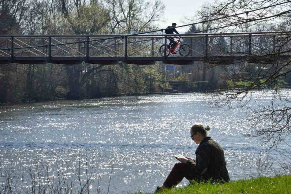 In Kassel genießt eine Frau an der Fulda die Sonne.