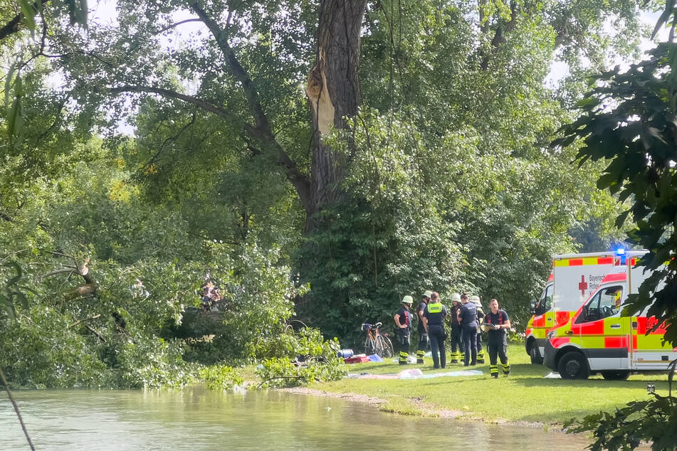 Rettungskräfte stehen an der Unglücksstelle im Englischen Garten in München.