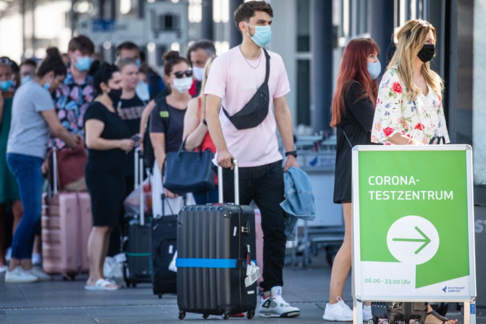 August 2020: Reiserückkehrer, vorwiegend aus Spanien, stehen mit Mundschutz vor dem Corona-Testzentrum am Flughafen Stuttgart.