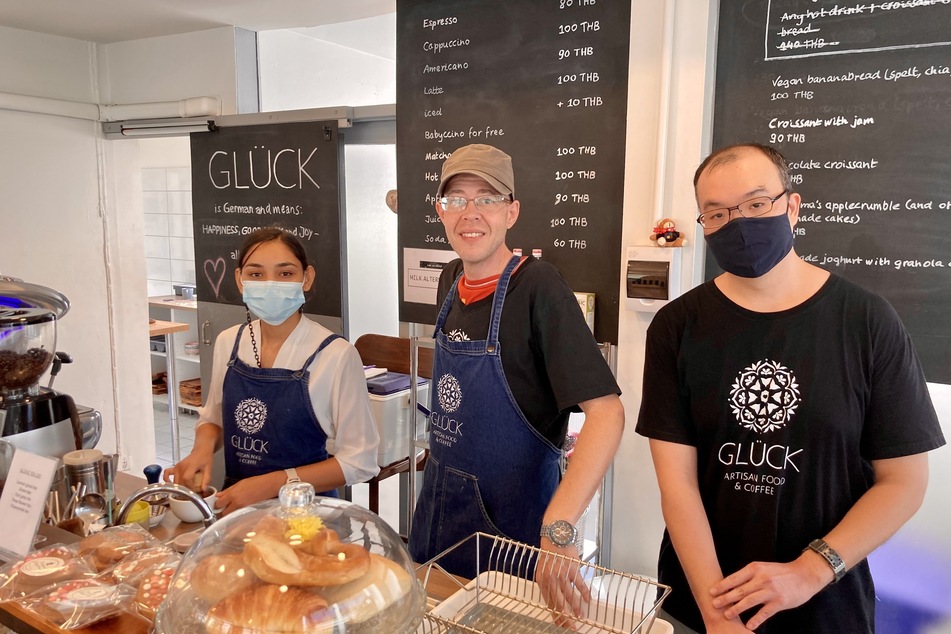 Mit seinen neuen Kollegen steht Matthias Bück (Mitte) hinter der Theke im Café Glück in Bangkok. Dort wagt er einen Neuanfang.