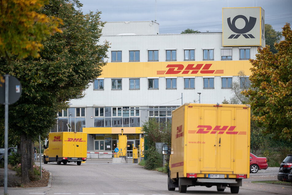 DHL-Lastwagen fahren auf ein DHL-Frachtzentrum zu. (Symbolbild)