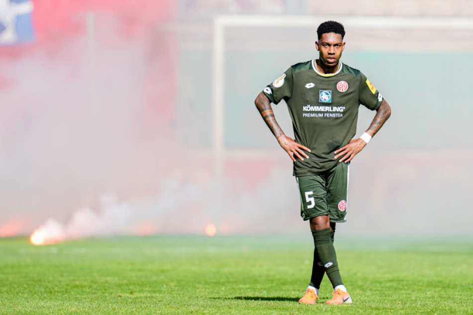 Jean-Paul Boetius von Mainz steht vor aufs Spielfeld geworfenen brennenden Bengalos.