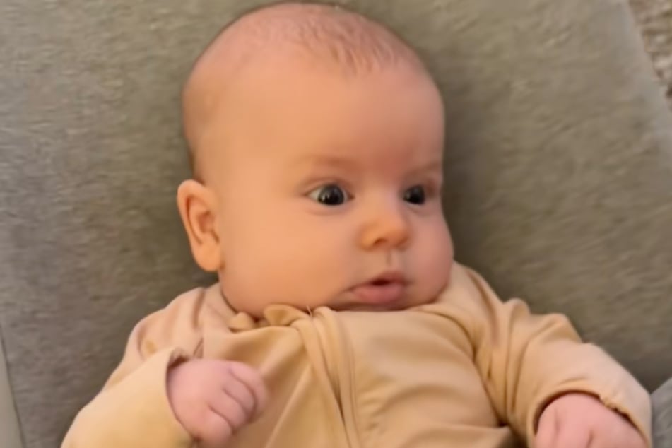 Baby Makenzie sieht die beiden Fellnasen skeptisch an.