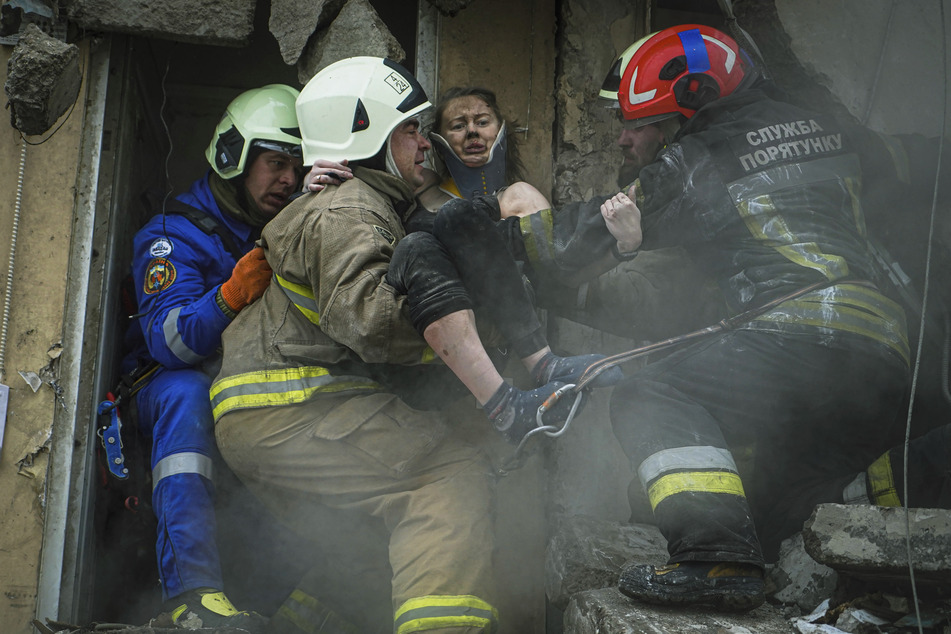 Aus dem bei einem russischen Raketenangriff in Dnipro zerstörten Wohnhaus wird eine Frau gerettet.
