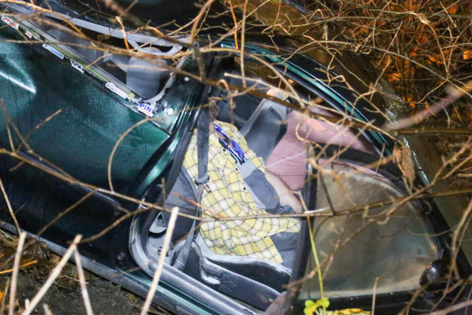 Ein Fahrzeug steckt in einer Böschung fest. Eine Person wurde eingeklemmt und befreit.