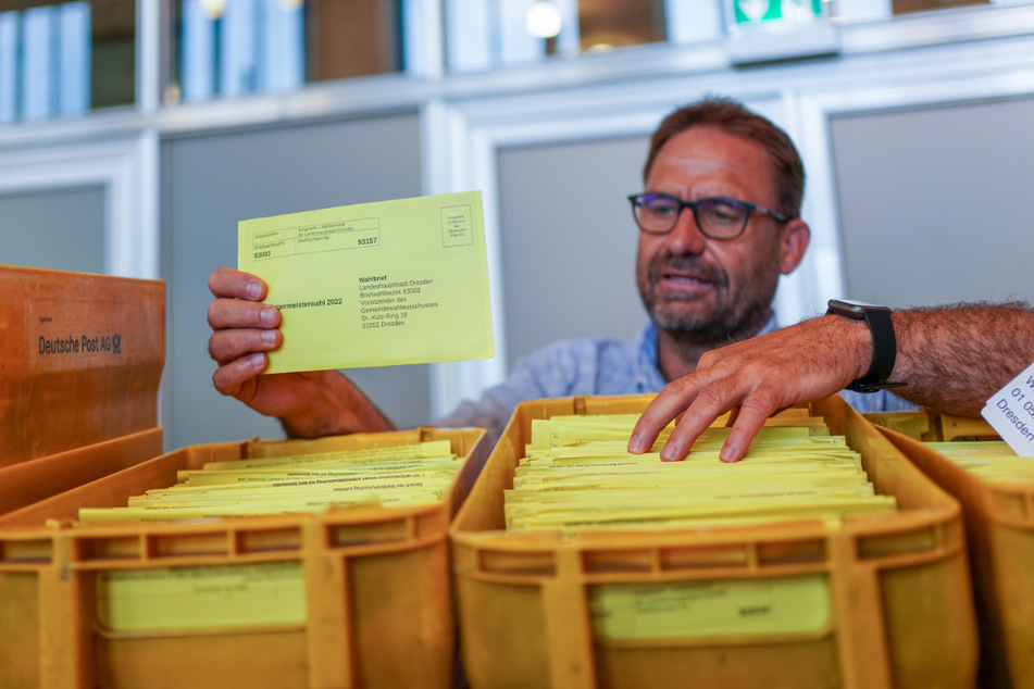 Die rechte Hand von Wahlleiter Blocher: Sven Mania (52) ordnet neu eingegangene Briefwahlunterlagen einem der Sammelbehälter zu.