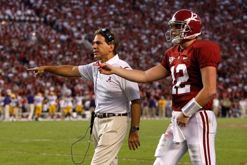 Former Alabama quarterback and national champion Greg McElroy (r) led coach Nick Saban's (l) Alabama team to an undefeated 14-0 season that capped off with SEC Conferences and national championship titles in 2009.