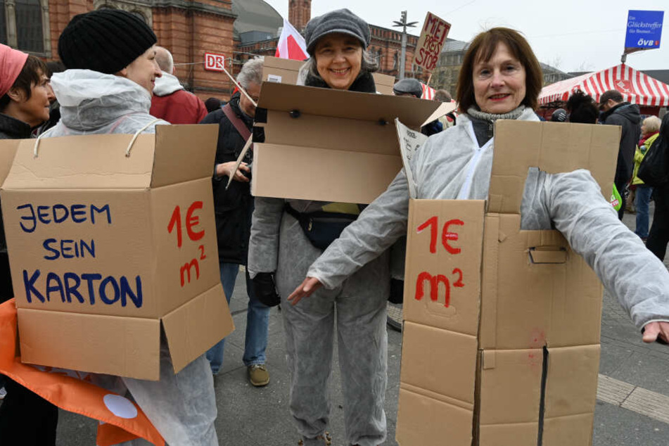 Teilnehmer der Demonstration "Die Stadt muss allen gehören", haben sich für mehr bezahlbaren Wohnraum Kartons angezogen.