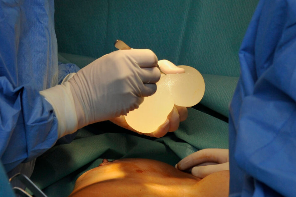 Chirurgen setzen einer Frau ein Silikon-Implantat in die Brust ein. (Archivbild)