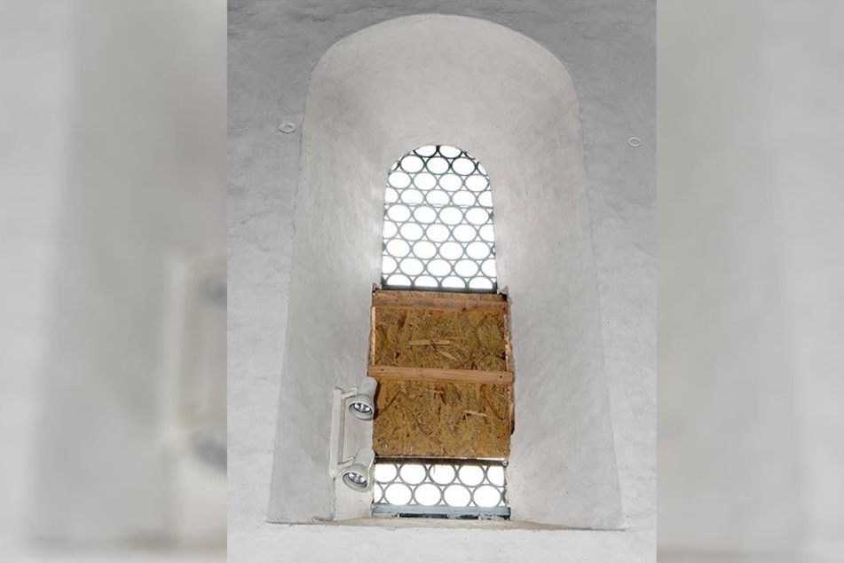 Hier drang der Vandale in die Kirche ein: Das eingeschlagene Bleiglasfenster wurde notdürftig "geflickt".