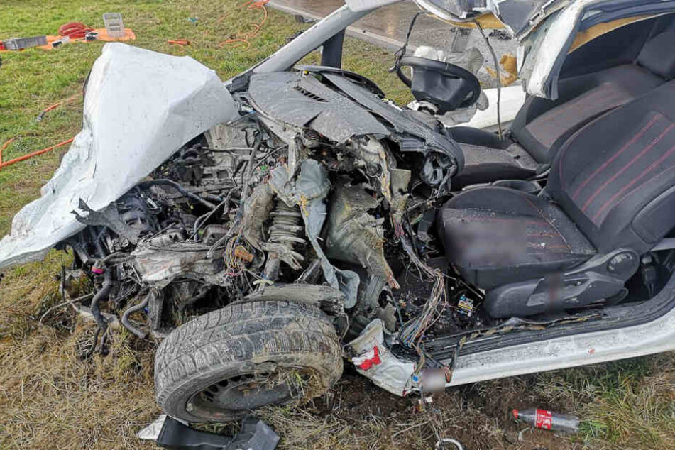 Das Wrack des Autos steht auf einer Grünfläche.