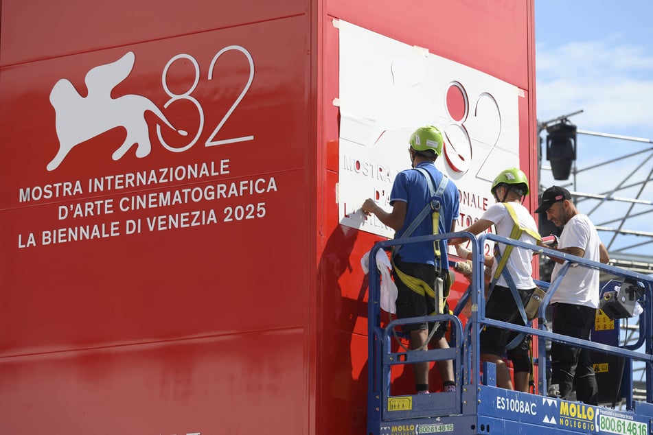 Workers install the logo of the 82nd Venice International Film Festival ahead of the event on August 24, 2025.