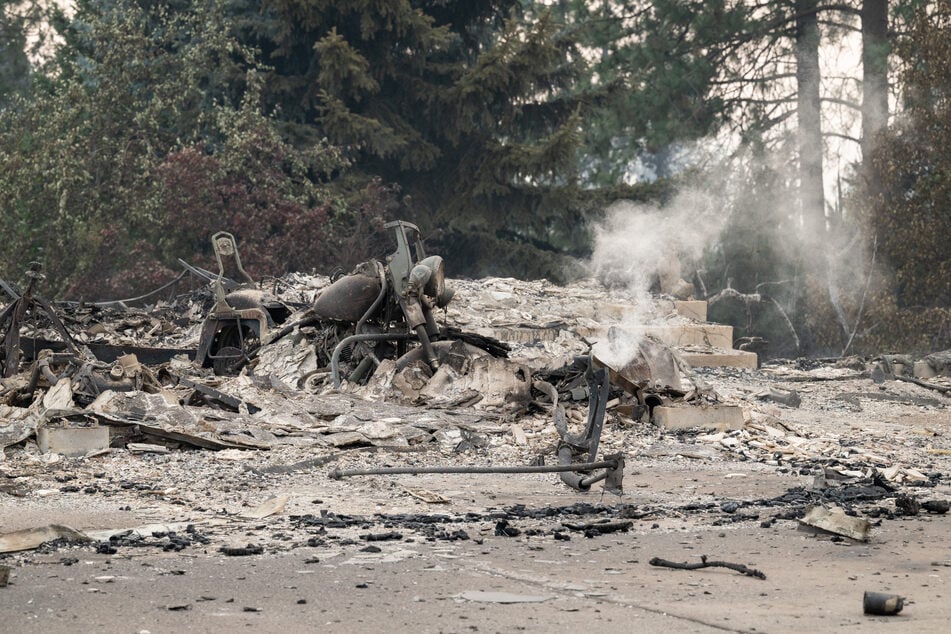 A burned motorcycle sits in the ashes of burned out residential home in the Balboa neighborhood of Spokane, Washington, on August 2, 2026.