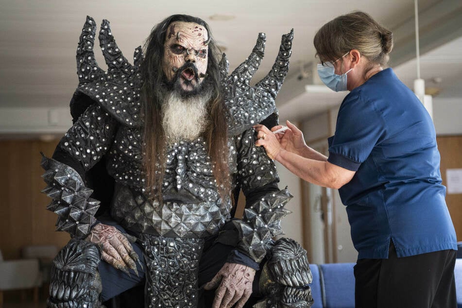 Mr. Lordi (47), Sänger der finnischen Hard-Rock-Band Lordi, wird von der Krankenschwester Paula Ylitalo die zweite Dosis eines Corona-Impfstoffs injiziert.