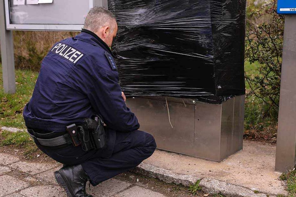 Aus der Nähe begutachtet ein Polizist den entstandenen Schaden.