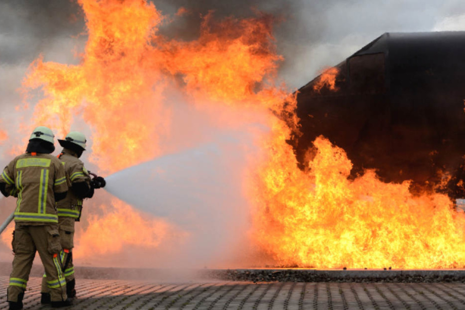 Die Berliner Feuerwehr bei Löschübungen am Brandsimulator am Flughafen Schönefeld.