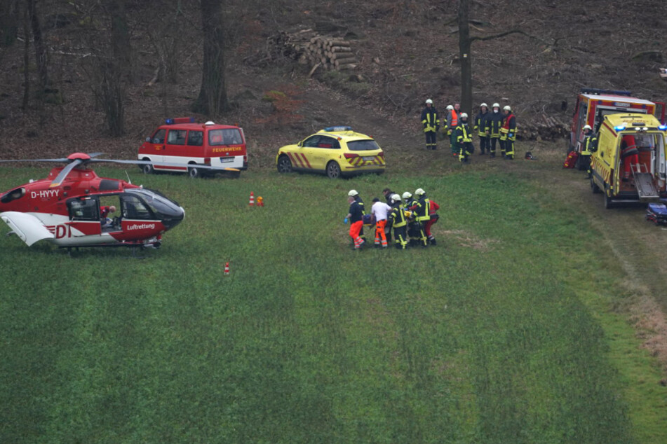 Kameraden und Sanitäter bringen den Schwerverletzten zum Hubschrauber.