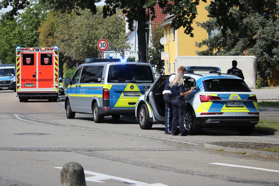 Polizei und Rettungsdienst stehen am Tag der Tat in der Nähe des Auffindungsortes der verletzten Frau.