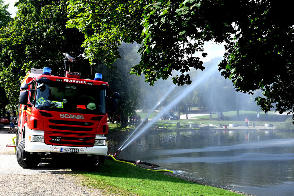 Die Münchner Feuerwehr pumpt Wasser aus dem Westparksee und spritzt es anschließend auf die Wasseroberfläche zurück.