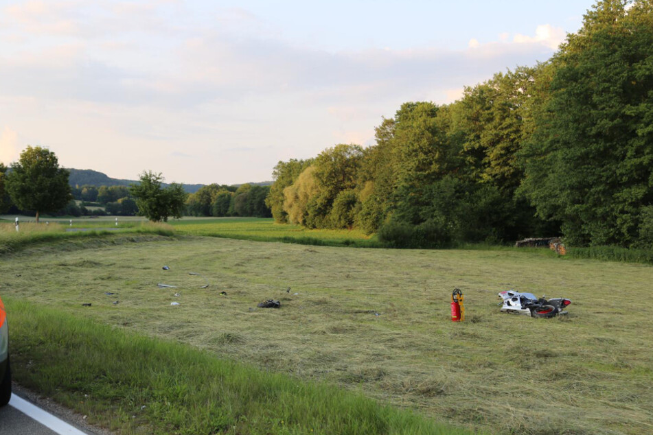 Trümmerteile liegen auf der Wiese verteilt.