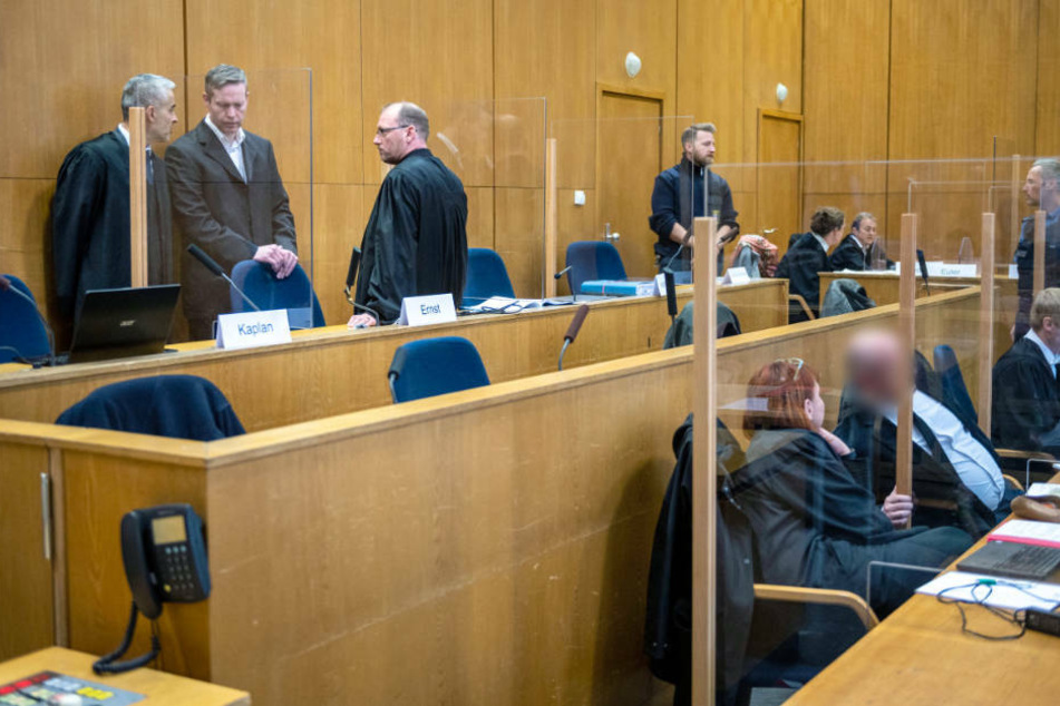 Der Angeklagte Stephan Ernst (hinten 2.v.l.) steht mit seinen Anwälten Mustafa Kaplan (hinten l.) und Jörg Hardies (hinten 3.v.l.) im Gerichtssaal im Oberlandesgericht Frankfurt.
