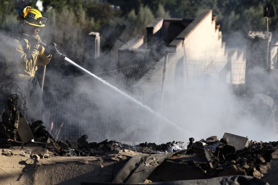 A Los Angeles Fire Department Station 105 firefighter hoses down hotspots at a home which was destroyed in the Mountain Fire on November 8, 2024, in Camarillo, California.