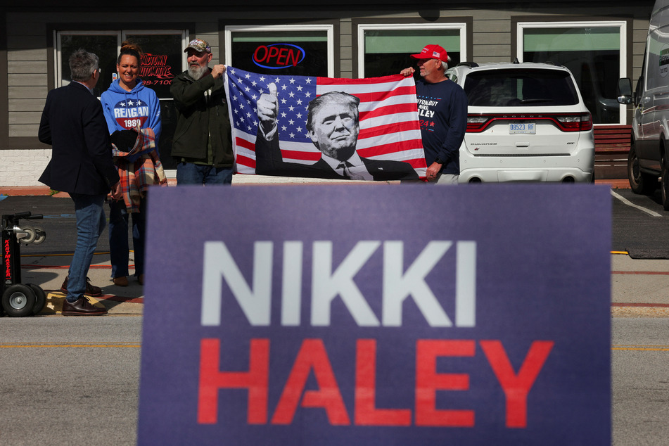 South Carolina voters hold a flag with a photo of Donald Trump, as Nikki Haley makes a campaign stop in Moncks Corner ahead of the state's Republican presidential primary election.