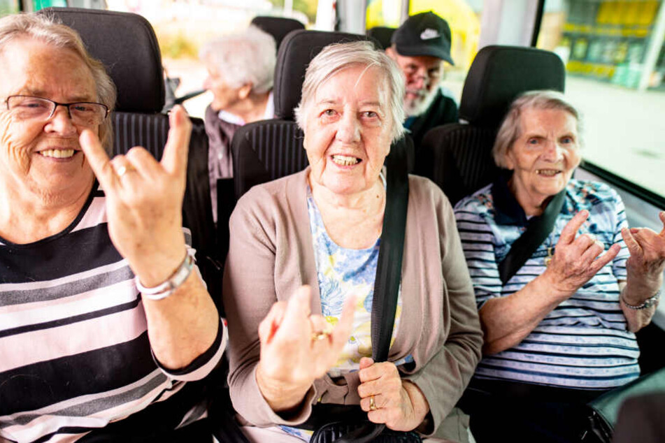 Ursula Wiebers (83, von links nach rechts), Ilse Schaefer (92) und Waltraud Fischer (95) stimmen sich auf den Wacken-Ausflug mit dem Metal-Gruß ein.