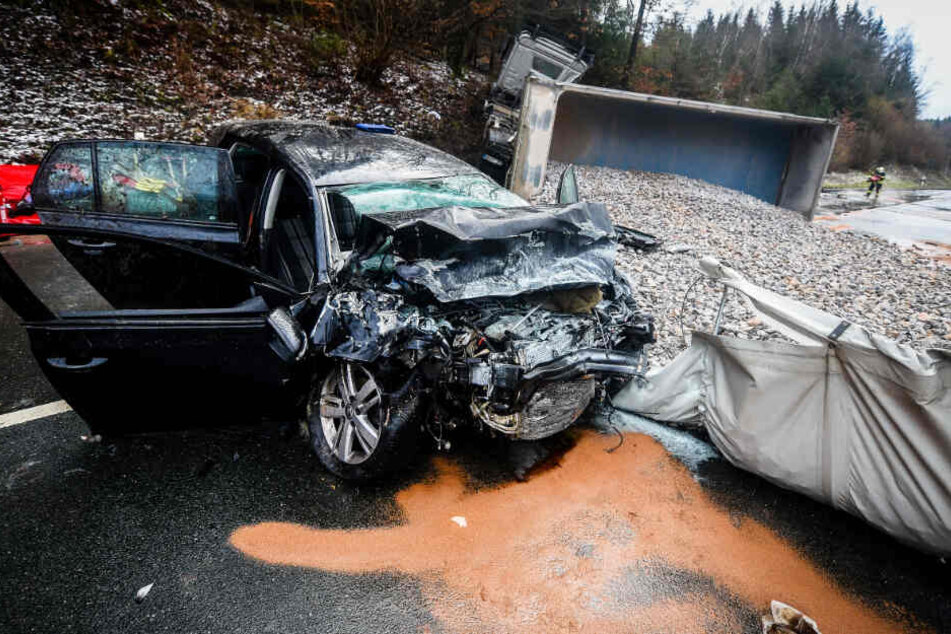 Bei einem schweren Verkehrsunfall auf einer glatten Straße ist die Beifahrerin eines Autos gestorben, nachdem ein Kieslaster umgekippt und mit dem Wagen kollidiert war.