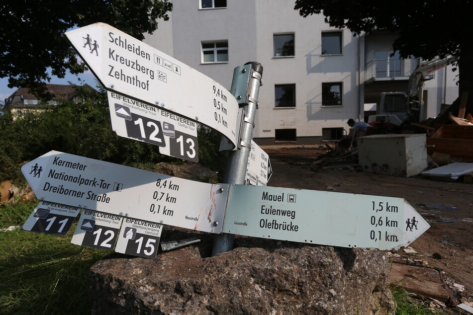 Verbogene Hinweisschilder liegen nach der Flutkatastrophe im Ortsteil Gemünd auf dem Boden.