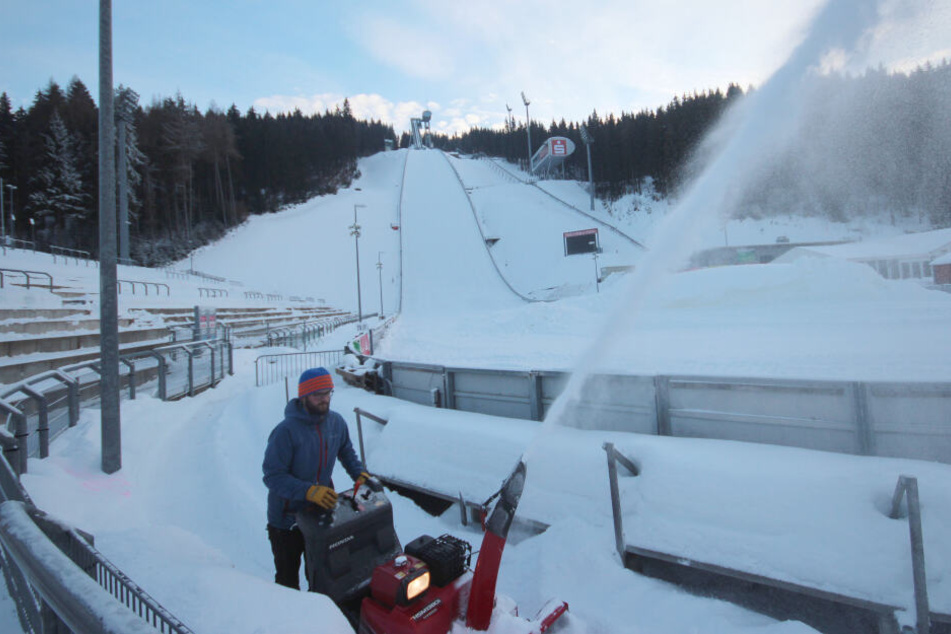 Marcus Stark vom VSC ist mit der Schneefräse unterwegs, um die Zuschauertraversen von der weißen Last zu befreien.