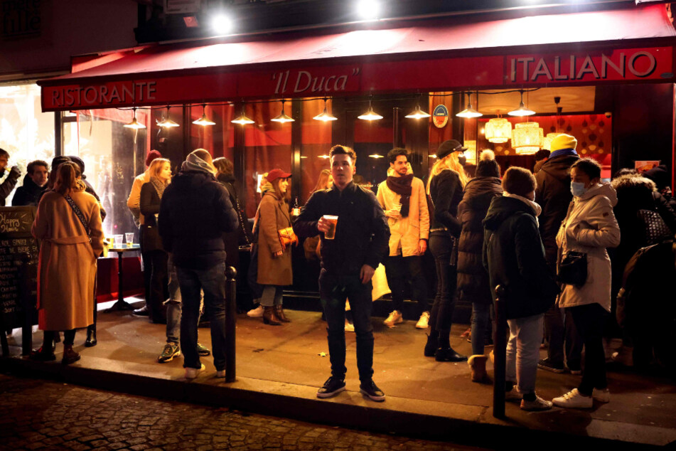 Paris: Gäste stehen und trinken auf dem Bürgersteig vor einer Bar am Vorabend der neuen Corona-bedingten Ausgangssperre.