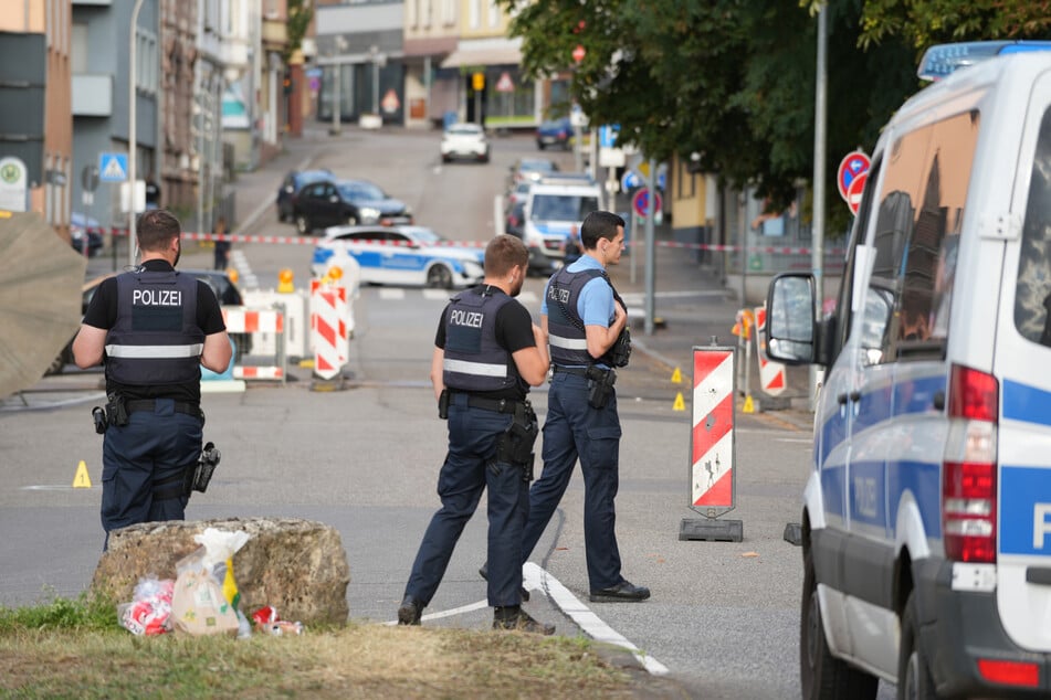 Polizeibeamte untersuchen das Umfeld des Tatorts.
