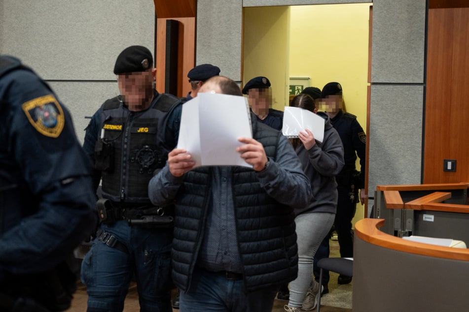 Die Angeklagten werden von Justizbeamten in das Landgericht geführt.