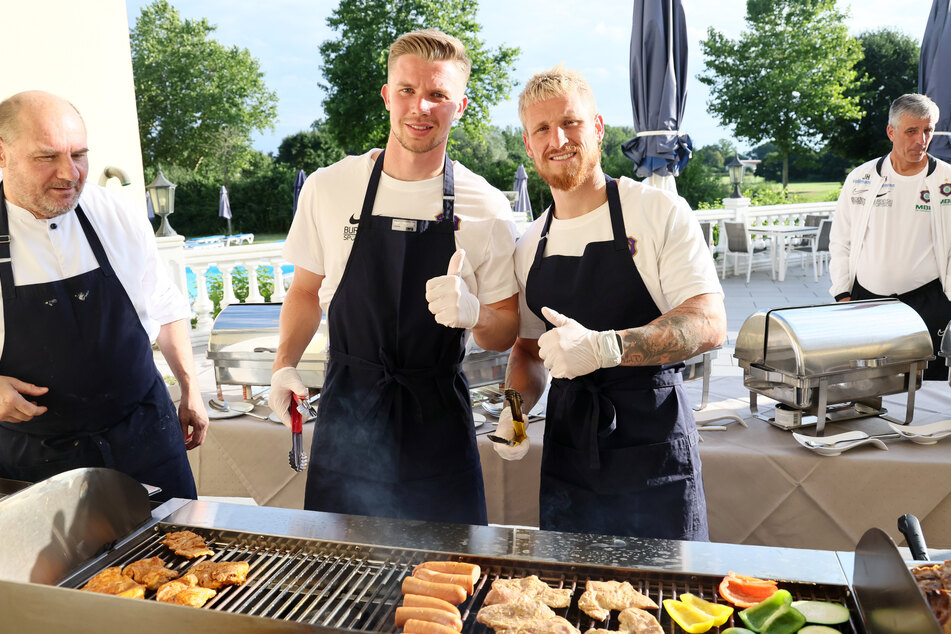 Erik Majetschak (25) und Marvin Stefaniak (30, r.) vom "Verlierer"-Team mussten grillen - was sie aber offenbar gerne machten.