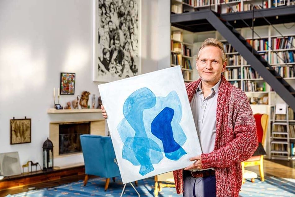 Architekt Jens Heinrich Zander (48) zeigt im Wohnzimmer von Stefan Heinemann (67) das Ölbild "Layers" von Christof Kraus, das auf dem Kunstmarkt für 750 Euro angeboten wird.
