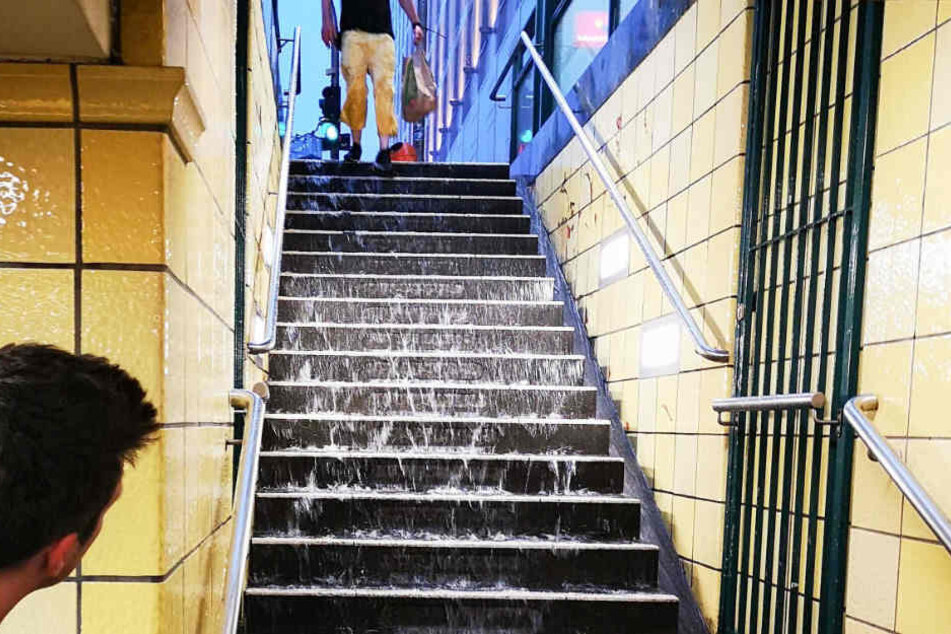 Nach schweren Regenfällen läuft Wasser die Stufen zum U-Bahnhof Friedrichstraße runter.