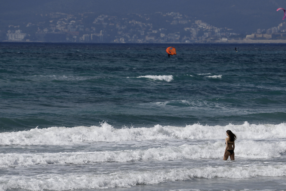 Eine Frau geht am Strand von Arenal zum Schwimmen in die Wellen. Seit dem 14. März müssen Deutsche, die Mallorca und mehrere andere spanische Urlaubs-Regionen besuchen, bei der Rückkehr nicht mehr in Quarantäne gehen.
