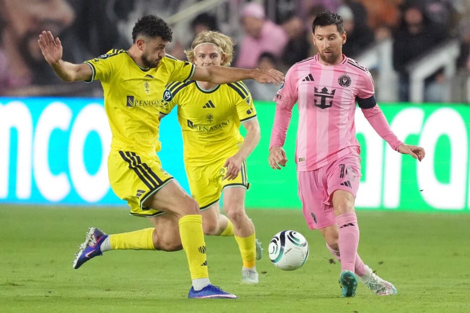 Inter Miami forward Lionel Messi looks to pass the ball as Nashville SC midfielder Patrick Yazbek closes in during the second half at Chase Stadium on March 18, 2026.