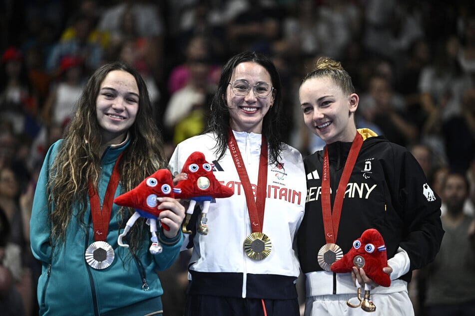 Para-Schwimmerin Alice Tai (25, M.) nach ihrem Gold-Sieg über 100 Meter Rücken mit Viktoriia Ishchiulova (19, l.) und Mira Jeanne Maack (20) aus Deutschland.