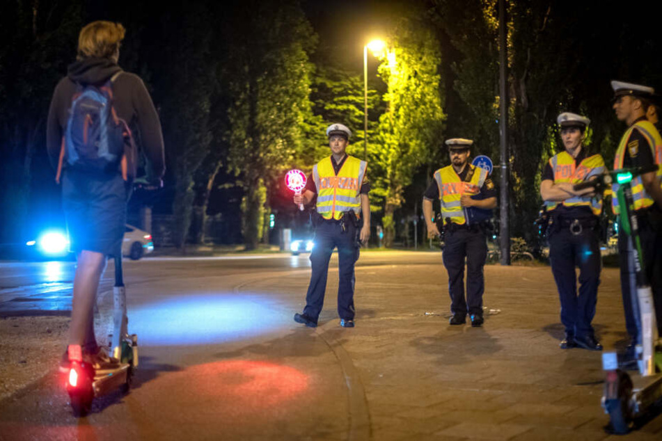 Polizisten kontrollieren einen E-Scooter-Fahrer.