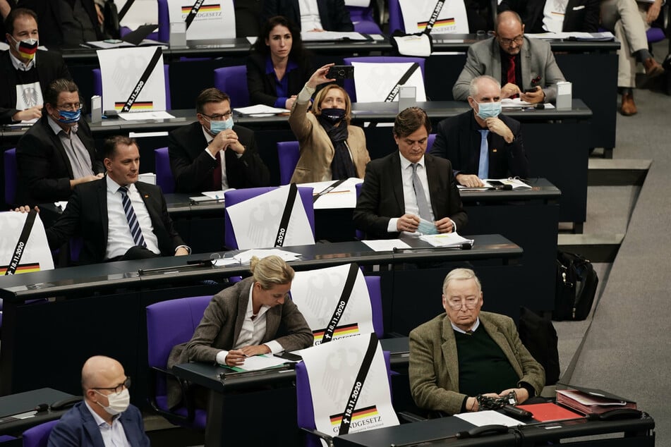 AfD-Abgeordnete der AfD mit Plakate mit der Aufschrift Grundgesetz und dem heutigen Datum in der Debatte vor der Verabschiedung der Änderung des Infektionsschutzgesetzes im November 2020.
