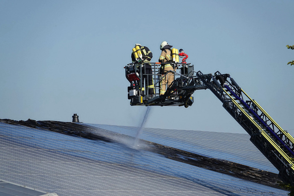 Die Kameraden der Feuerwehr löschen die Solaranlage auf dem Dach.