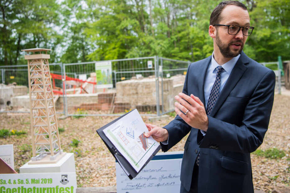 Jan Schneider, Baudezernent der Stadt Frankfurt, zeigt neben dem Holzmodell des neuen Goetheturms die Pläne für den Wiederaufbau.